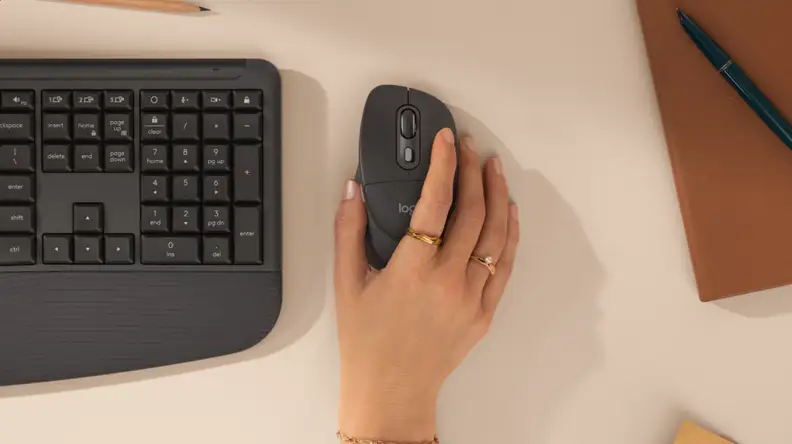 Black Logitech Signature Comfort Plus MK880 keyboard and mouse with right hand using the mouse.
