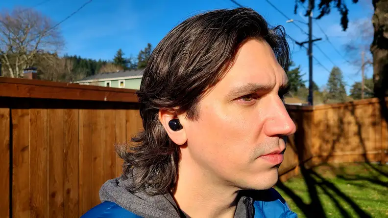 A Reviewed editor listens to music outdoors with the Samsung Galaxy Buds Pro.