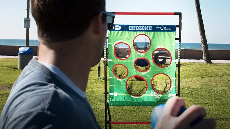 A person throws a sandbag into a goal.