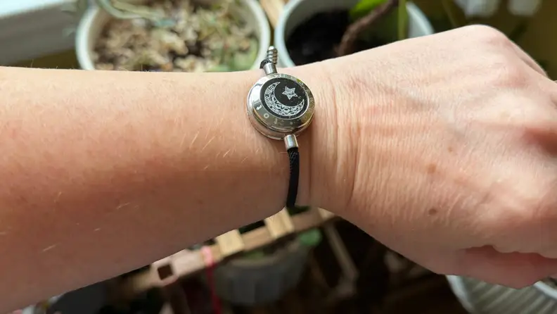 An arm reaches out with a bracelet on it