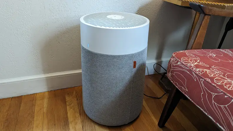 A Blueair Blue Pure 311i Max air purifier filter sits on the floor in a residence.