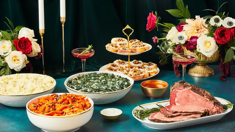 Prime rib on a decorated holiday table with sides.