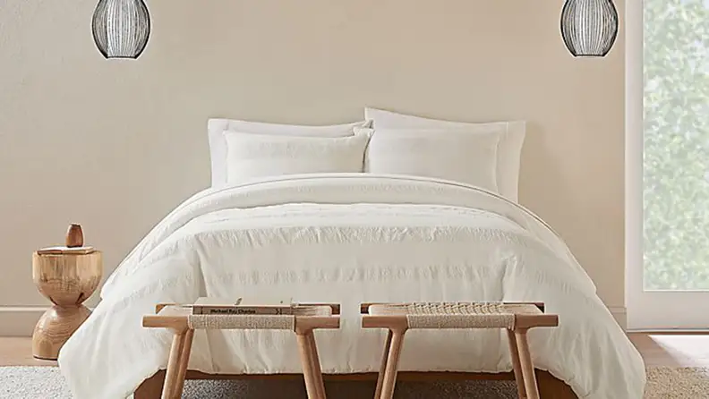 A bed with white sheets.