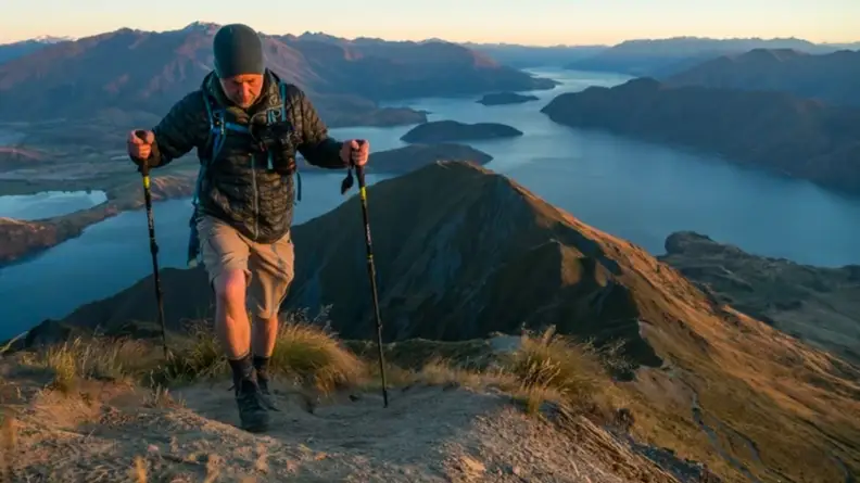 Man hiking on top of mountain wearing Darn Tough Vermont socks.