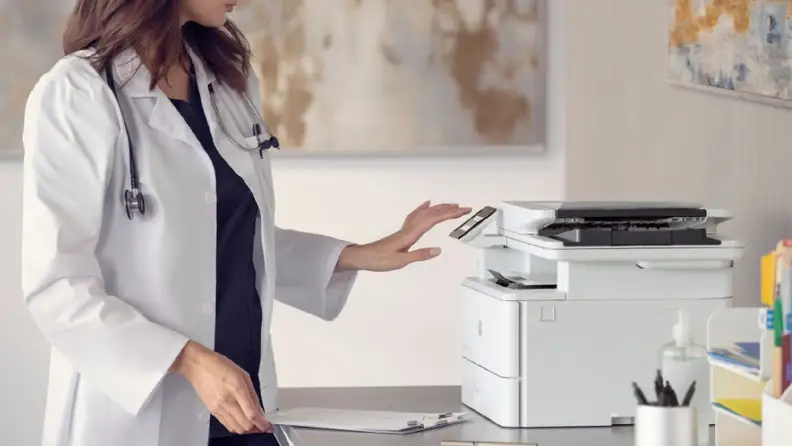 A healthcare worker using the touchscreen on an HP LaserJet Pro 4101fdw.