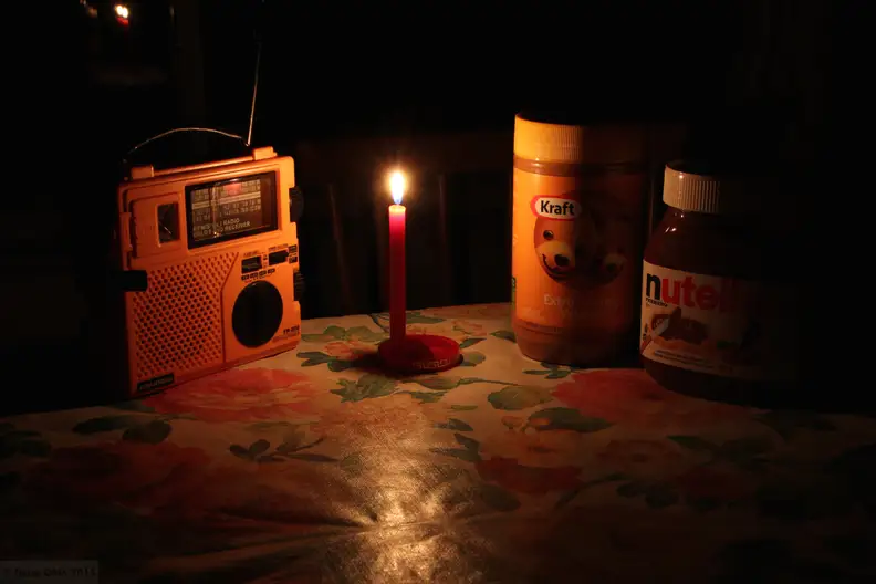 A radio and food under candlelight during a power outage