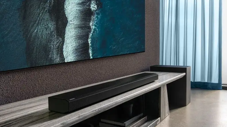 A Samsung sound bar beneath a television.