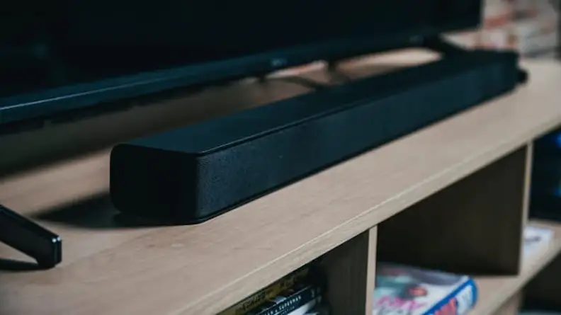 Soundbar sitting on TV stand in living room.