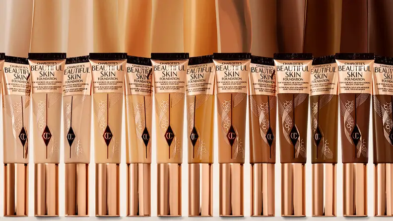 A line of foundations from light to dark shades in squeeze tubes with swatches of the shades above each bottle.