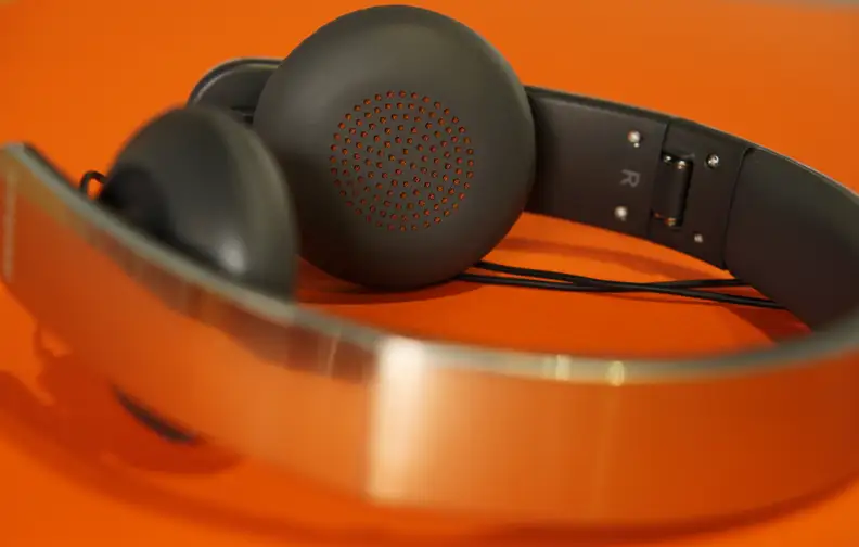 The perforations on the earcups hide the only pop of color on the otherwise silver and grey headphones.