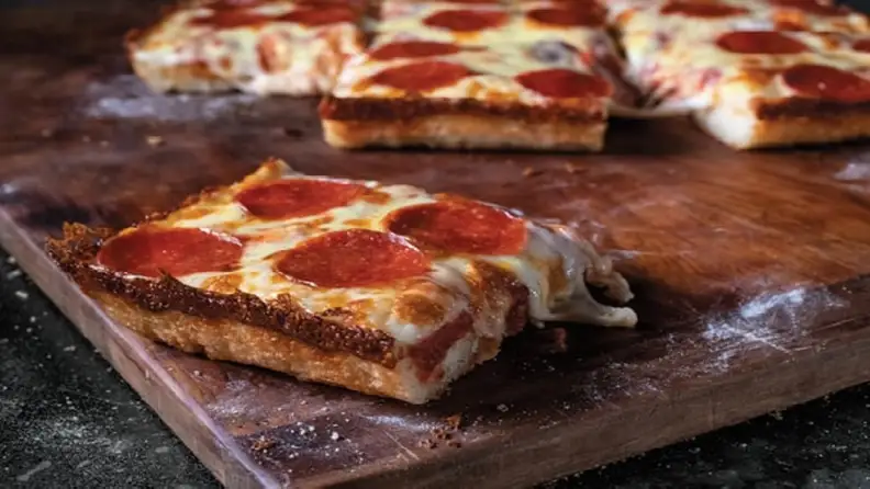 Detroit-style pepperoni pizza slices on a wooden board