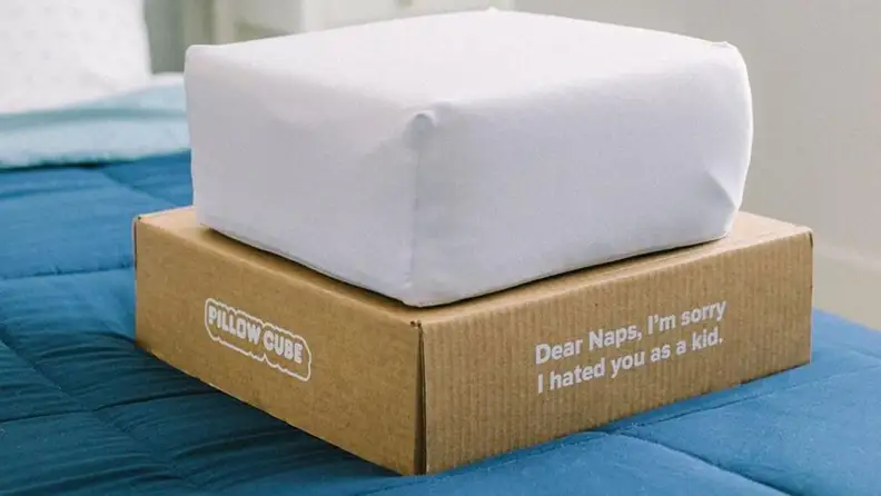 the pillow cube on its box atop a mattress