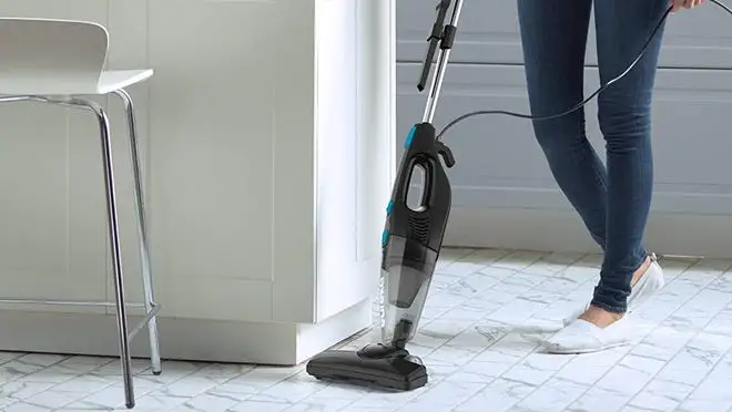 Person vacuuming floor with white flats on.