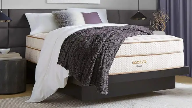 Assembled bed with pillows and blankets in bedroom.