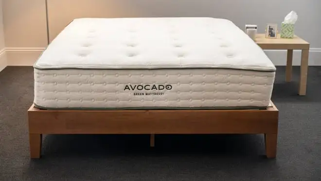 White mattress on top of wooden bed frame.