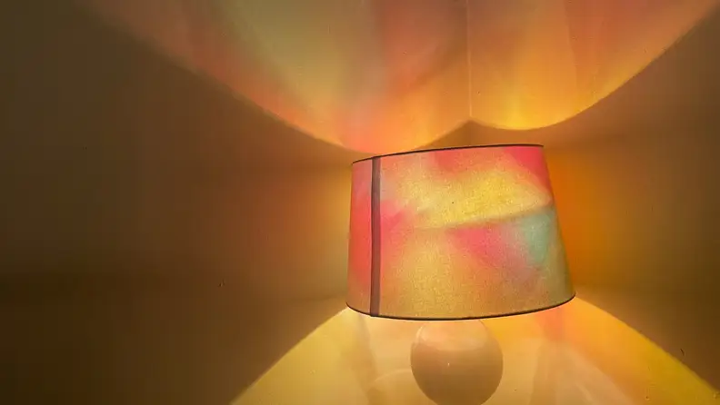 A lamp lights a room with red, orange and yellow light