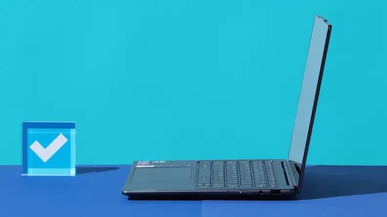 Viewing an open laptop from the side against a blue background