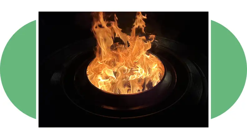 Nighttime shot of the Solo Stove Surround with a flame burning in the firepit.