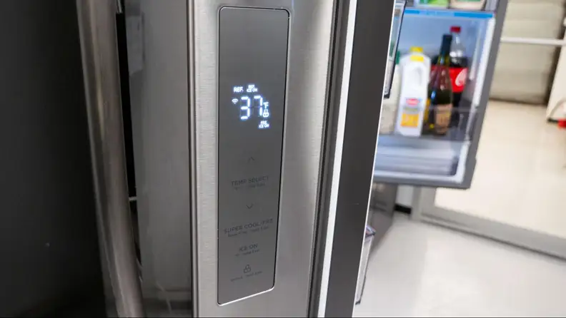 A close-up of a refrigerator’s control panel displays that the fridge temperature is 37°F.
