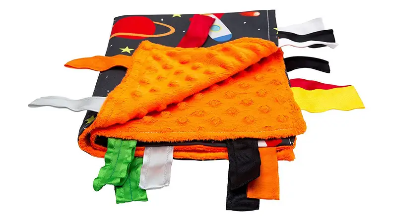 An orange blanket with ribbons hanging off the side