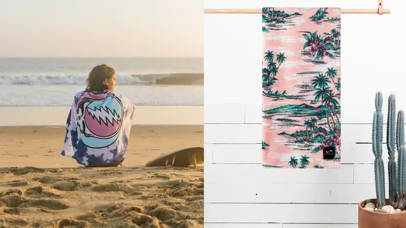 Person sitting on the beach wrapped in a Grateful Dead towel / Tropical print towel hanging.