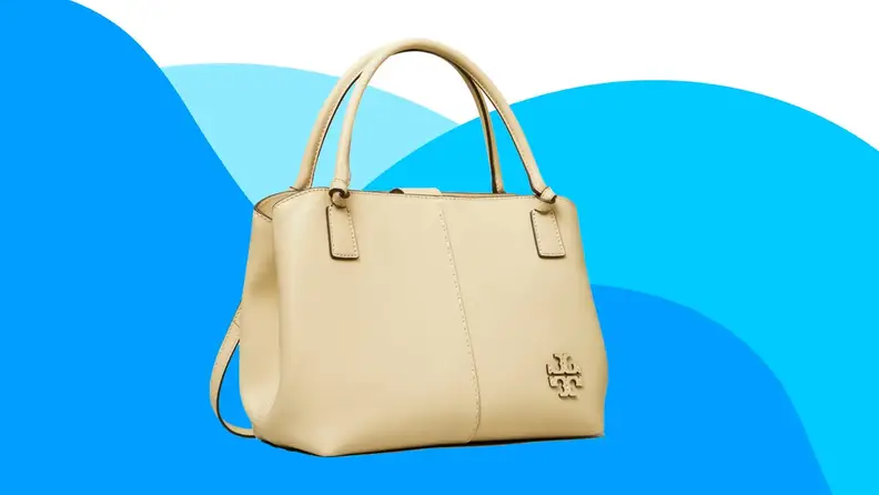 Cream leather handbag in front of blue background.