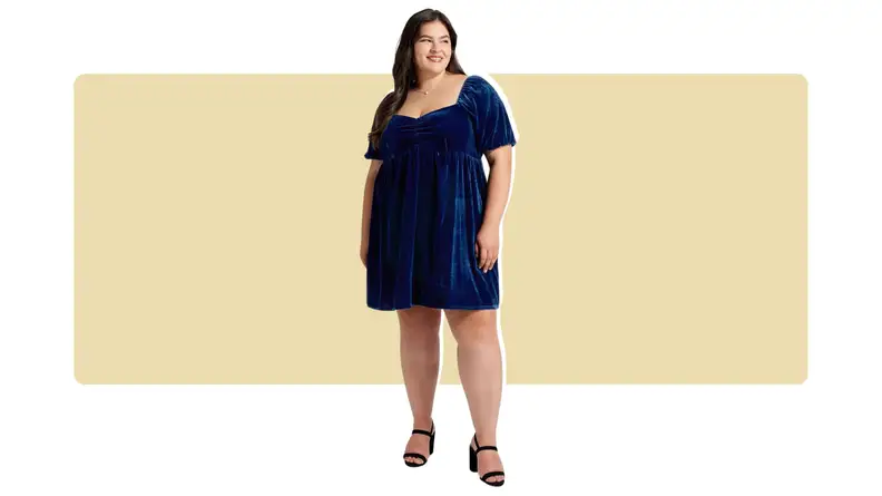 A model wearing a knee-length blue velvet dress.