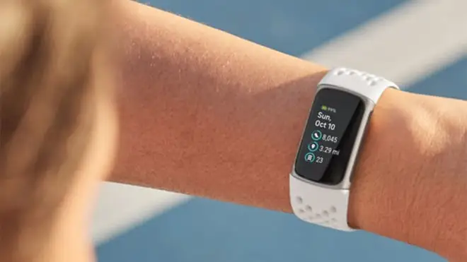 A person wears a Fitbit.