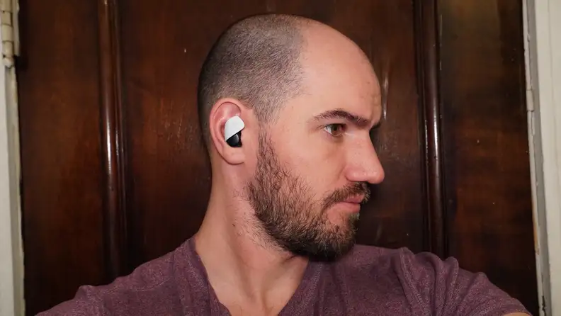 A man's face looking to the side while the Sony Pulse Explorer are attached to his ear.