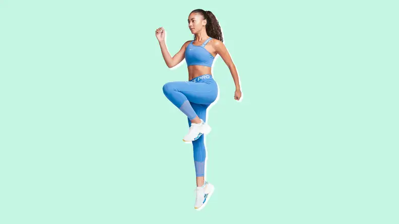 A woman doing leg lifts in blue Nike Pro Leggings.
