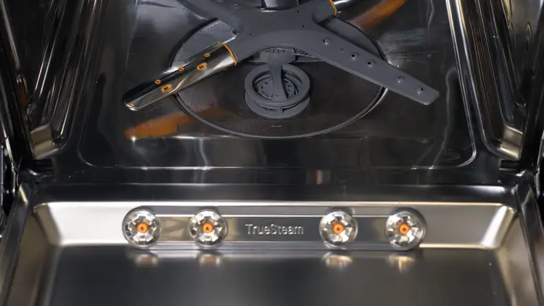 A close-up of the inside of the dishwasher's door, which has four steam nozzles towards the bottom.
