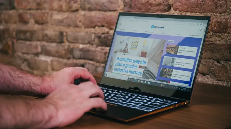 Person types on laptop keyboard
