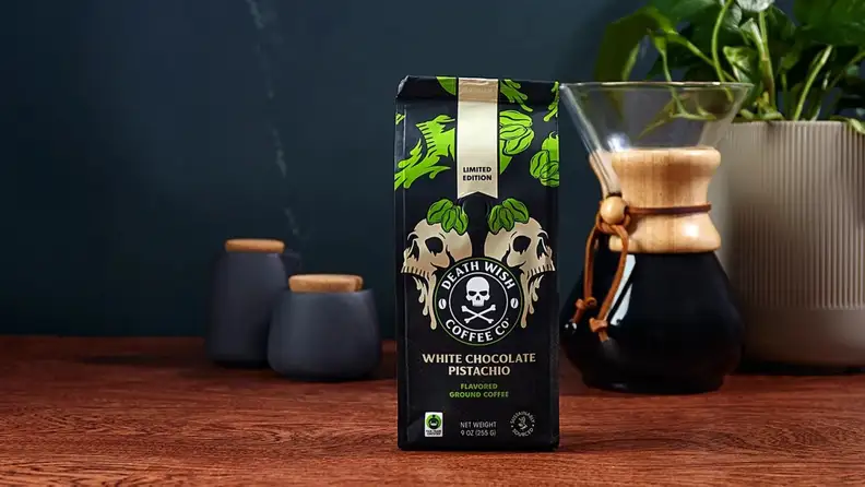 Coffee bag beside a pour-over glass carafe and plant