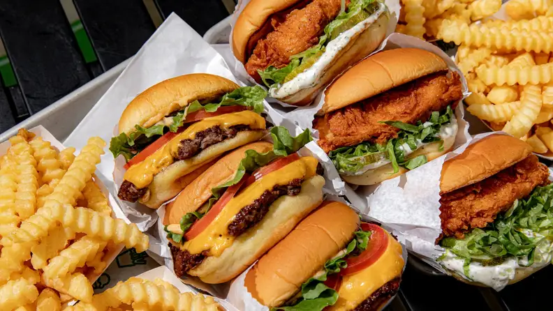 An overhead shot of Shake Shack burgers, a chicken sandwich, and crinkle-cut fries