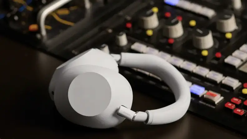 Sony WH 1000XM6 white headphones laying on a sound control board.