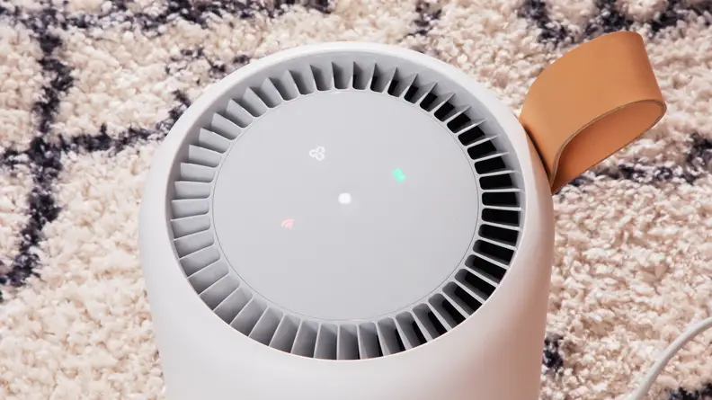 The Molekule air purifier is shown from above with its top face and button visible.