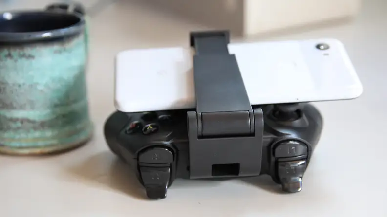 A phone clipped to a HyperX Clutch game controller.