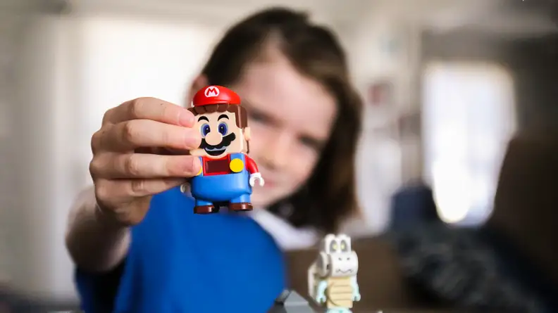 A child holds the Super Mario Lego toy.