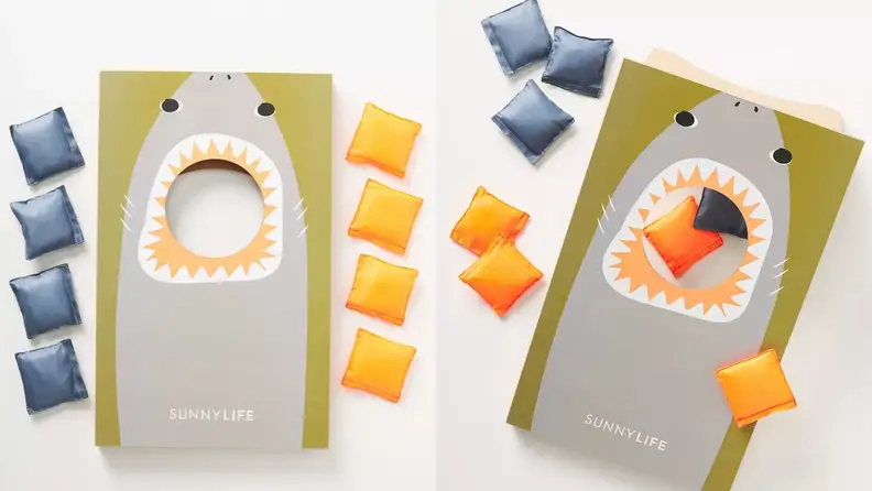A shark-themed cornhole board with yellow and blue cornhole beanbags