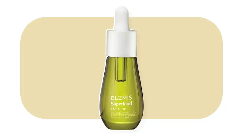 Elemis face oil in front of a mustard-colored background.