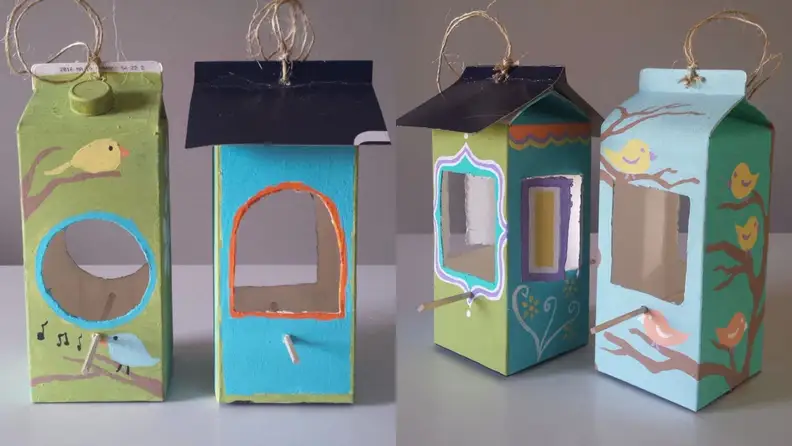 Two bird houses made from empty milk cartons.
