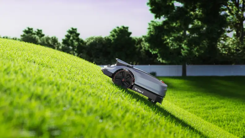 A Sunseeker Elite X5 Gen 2 robotic mower climbs a steep grassy slope.