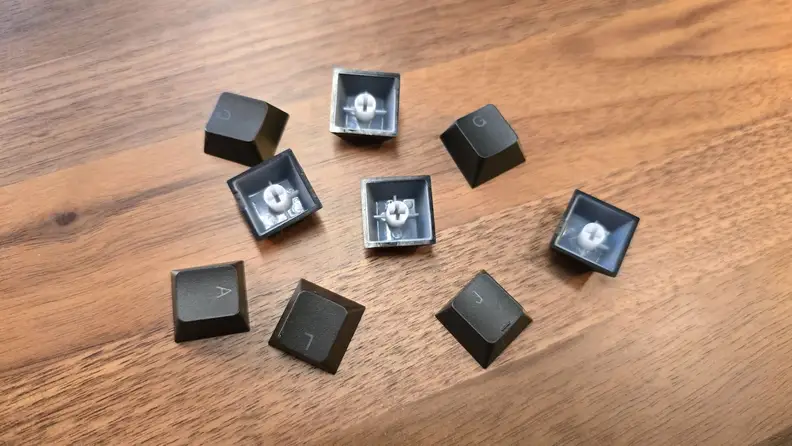 The NZXT Function 2 keyboard keys detached from the keyboard and on a desk.