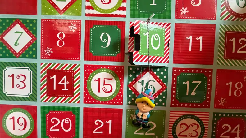 An ornament hangs from a numbered box on an advent calendar