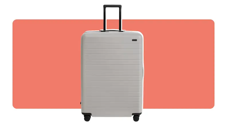 A gray hard shell Away Large roller bag with handle extended.