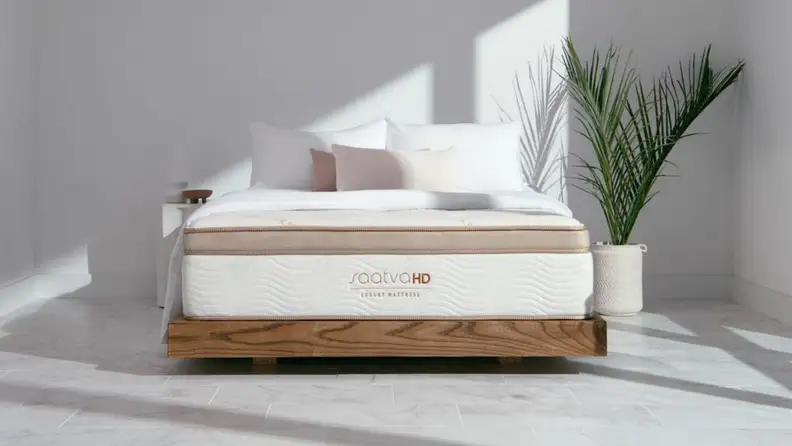 A Saatva mattress inside a minimalistic bedroom.