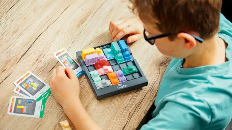 A boy plays with the Rush Hour game