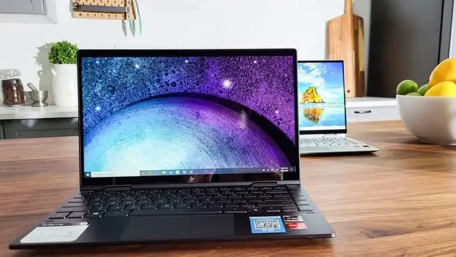 A photo of an HP Envy laptop on a desk.