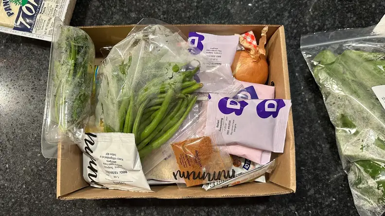 The inside of a Dinnerly box, with Dinnerly products inside the box.