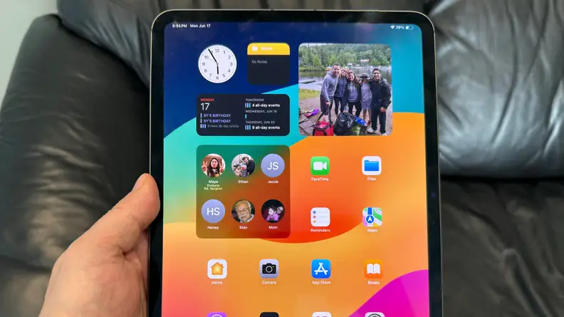 An iPad Pro being held by it's user in a portrait orientation.